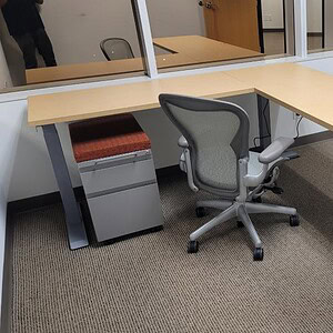 Herman Miller 6x6 L-shaped office desk with ergonomic chair.