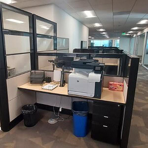 Modern office cubicle with triple glass walls and door, ideal for professional workspace.