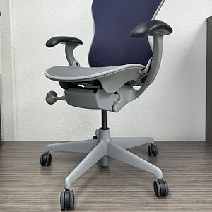Herman Miller Mirra office chair with grey seat and navy backrest, ergonomic design for comfort and.
