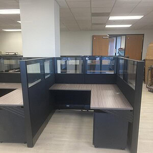 Office cubicle with black frame and glass walls, ideal for workspace organization and privacy.
