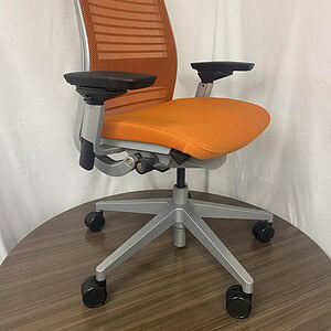 Ergonomic orange and silver office chair with adjustable armrests and mesh backrest.
