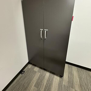 Grey and white storage cabinet with double doors, ideal for organizing tools, supplies, or office es.