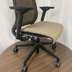 Ergonomic office chair with mesh back and beige fabric seat for comfort.