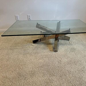 Chrome designer glass table with sleek, contemporary style for Warner Brothers production sets.