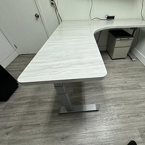 Height adjustable L-shaped desk for ergonomic workspace comfort.