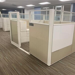 Modern Haworth office cubicle with sliding door and glass panels.