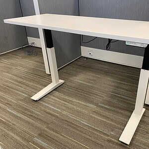 Height adjustable white desk for ergonomic workspace comfort.