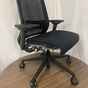 Black Steelcase Think ergonomic office chair with mesh back and adjustable features.