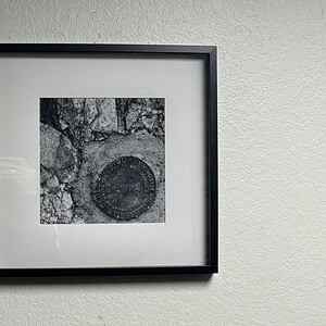 Stone geological art print in a black frame, showcasing natural textures and patterns.