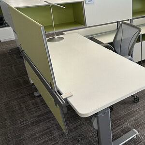 Acoustical panel divider with modesty panel in an office workspace, enhancing privacy and sound cont.