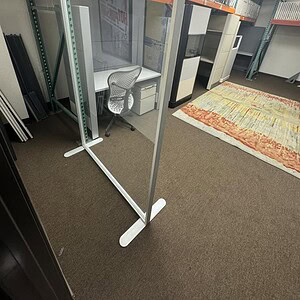 Glass panel room divider with sturdy steel frame for office privacy and separation.