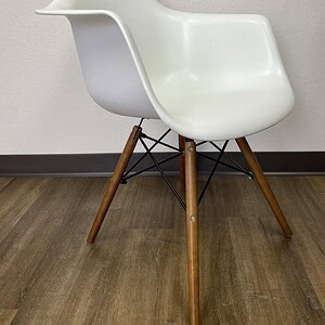 Style white bucket chair with wood legs, perfect for contemporary home or office decor.