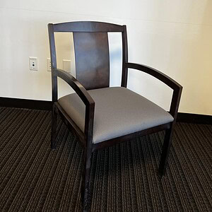 Executive guest chair with grey upholstery and dark wood frame, ideal for office reception areas.