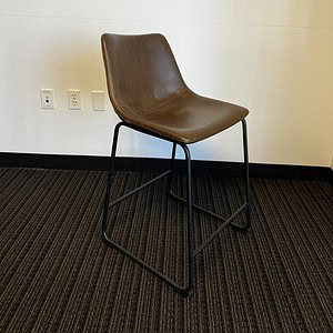 Brown leather stool with black metal frame for modern seating.