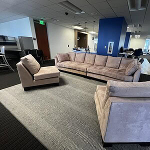 Pink velvet sofa with matching lounge chairs in a contemporary office lounge setting.