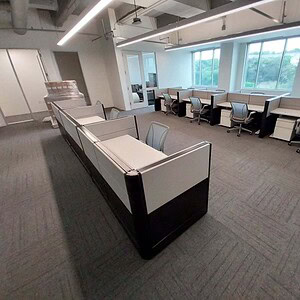 Modern office workspace with height-adjustable desks and ergonomic chairs.