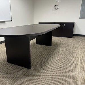 Black oval conference table ideal for meetings and office spaces.