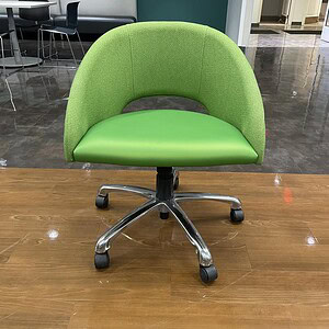 Green office chair with chrome base and casters for ergonomic comfort.