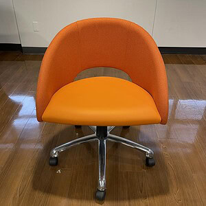 Bright orange office chair with chrome caster base, ergonomic design, ideal for workspace comfort.