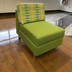 Modern green modular lounge chair with colorful backrest, ideal for office or lounge areas.