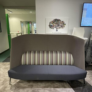 Back grey lounge sofa with striped cushion, modern office furniture.