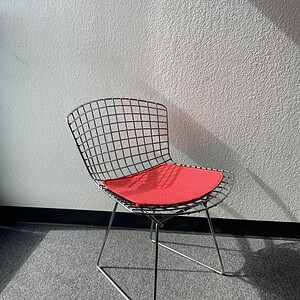 Vitra chrome wire chair with low back and red cushioned seat, modern design for stylish interiors.