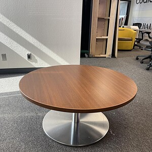 Round Steelcase low table with chrome base, ideal for office or lounge areas. Durable wood surface a.