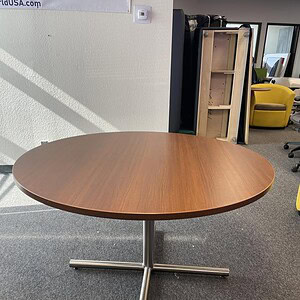 Round conference table with steel cross base, ideal for office meetings and collaborative spaces.