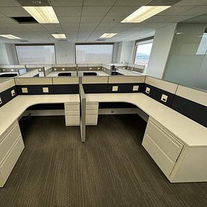 Modern office cubicles with large windows and natural light in a corporate workspace.