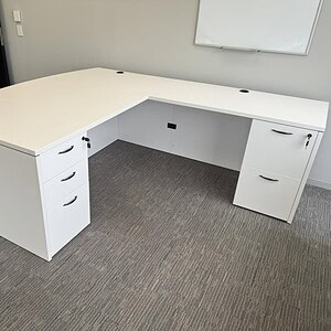 Modern white L-shaped desk with BBF storage drawers, ideal for office workspaces.