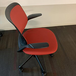 Red and black ergonomic task chair for office comfort and support.