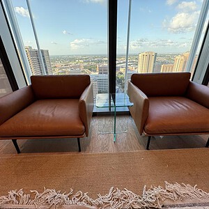Saddle brown leather lounge chairs with sleek design, perfect for upscale living spaces.