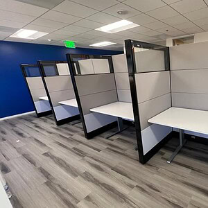 Ethospace 5x3ft T HAT table with glass top in modern workspace.