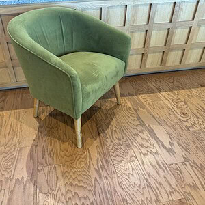 Green velvet mid-century modern lounge chair with wooden legs.