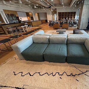 Contemporary three-piece charcoal and grey sectional sofa in stylish living room.
