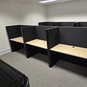 Modern Herman Miller Ethospace 4x2 office cubicles with black panels and beige work surfaces.