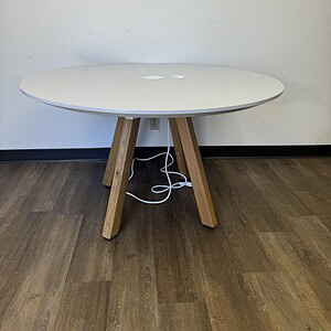 Round grey top table with wooden legs, ideal for modern dining or workspace settings.
