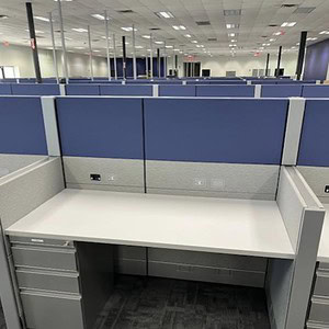 Modern office cubicle with blue fabric panels and white desk, ideal for professional work environmen.
