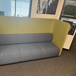Acoustical couch with two-tone yellow and gray fabric, ideal for modern office spaces and sound abso.