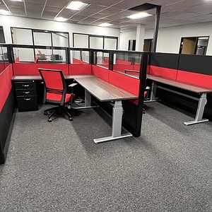 Office cubicles with red and black panels for modern workspace organization.