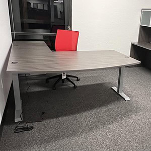 OFS HAT 6x7 bowfront desk with silver frame and slate grey top in modern office setting.