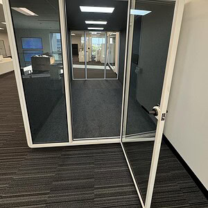 Modern white phone booth for offices, ideal for private calls and meetings.