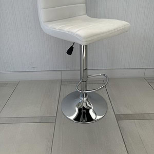 White leather pneumatic bar stool with chrome base and adjustable height. Perfect for modern bar or.