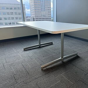 Modern Steelcase 6x3 white top table with steel base in office setting.