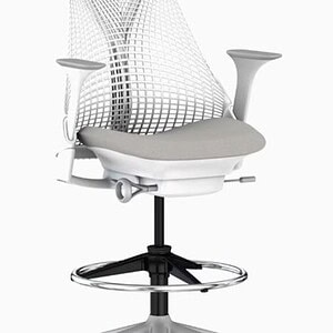 Herman Miller Sayl white ergonomic office chair with foot ring, mesh back, and adjustable height. Pe.