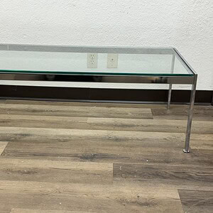 Glass Warner Brothers themed coffee table with metal legs.
