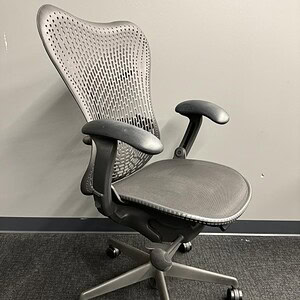 Office ergonomic Herman Miller Mirra chair with mesh back in graphite color.