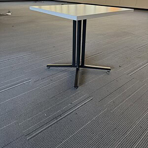 Modern black-based Herman Miller table in spacious office setting.
