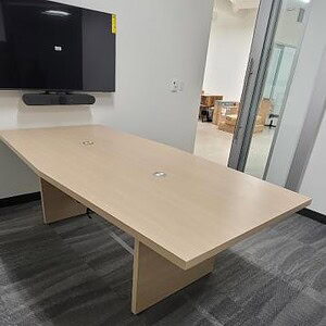 Modern beige wood conference table with Steelcase Payback 8x4 design in an office setting.