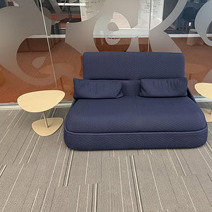 Modern blue Pandora sofa with matching pillows and side tables in a stylish lounge setting.